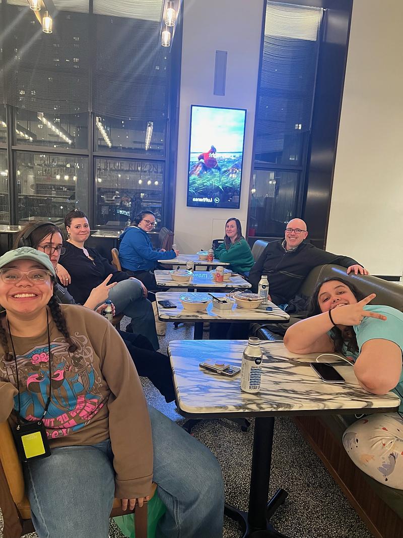 Students posing for photo inside restaurant