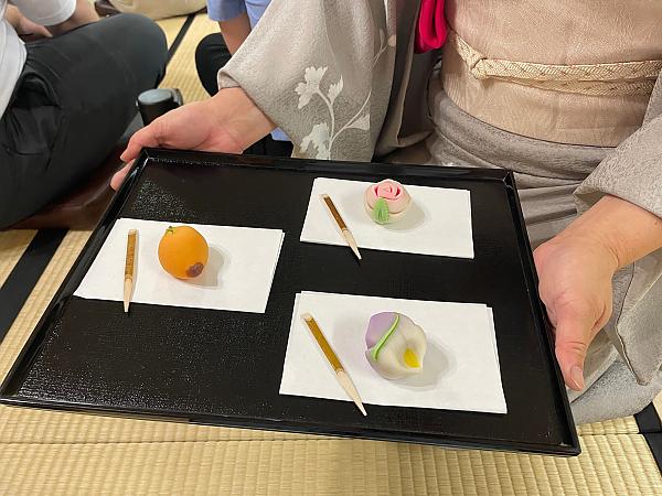 Tray with colorful tea ceremony treats on 3 different white plates