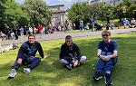 Three students sitting on St. Stephens Green on first day of the Ireland 2024 study abroad trip